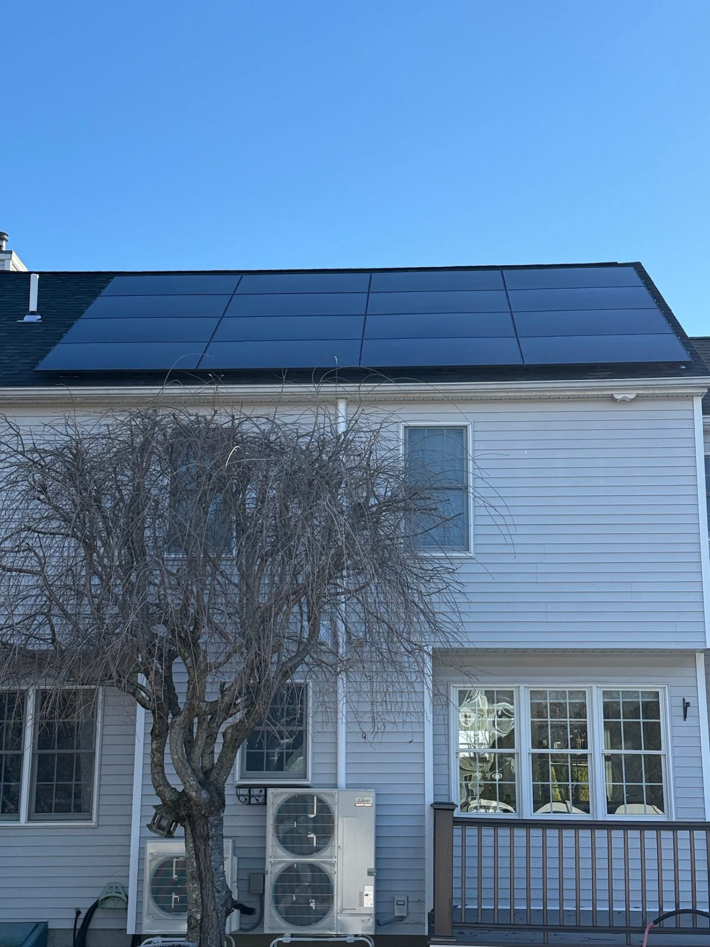 Close view of a flush-mounted all-black solar array on a residential shingle roof